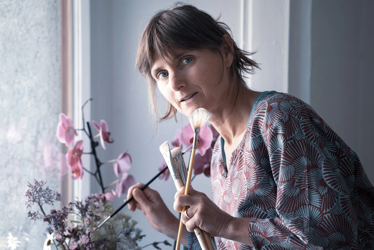 Marie avec ses pinceaux et des orchidées